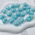 Nahaufnahme glänzender AB-beschichteter blauer Herzperlen für DIY-Schmuck und Handy-Anhänger. - Seeblau