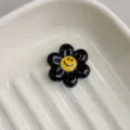 Black resin smiley flower charm detail, perfect for DIY jewelry making and cute craft accessories. - Black