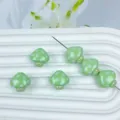 Vue détaillée de perles champignon vertes à pois blancs avec visages souriants pour bijoux. - Vert