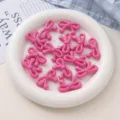 Detailaufnahme von rosa Acryl-Schleifenperlen mit Sternenden, ideal für DIY-Handyketten. - Leuchtendes Rosa