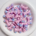 Acryl Makronen Schleife Perlen Nahaufnahme, süßes pinkes Tropfen-Design mit blauen Sternen. - Lila & Rosa