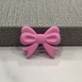 Nahaufnahme Detailansicht einer süßen rosa Schleife als Haar- oder Handyhüllen-Accessoire. - Fliege / Fuchsia