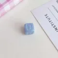 Primo piano dettagliato di perla a cubo in acrilico azzurro con lettera B in rilievo. - Azzurro
