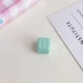 Dettaglio primo piano perlina quadrata con lettera in acrilico, accessorio gioiello DIY. - Verde chiaro