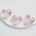 Vista dettagliata di perline a cuore sfaccettate iridescenti rosa trasparente, accessorio. - Cuore / Rosa