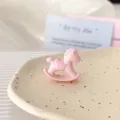 Close up of a cute pink rocking horse acrylic bead, perfect for DIY jewelry accessories and crafts. - Pink