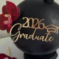 Adorno de pastel dorado 2026 Graduate con detalle de birrete para decoración de graduación. - Graduado Dorado / 1.3mm de Espesor Acrílico Aprox. 9cm de Ancho