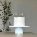 Detail shot of golden acrylic seventy cake topper on frosted white cake for anniversary. - Number Seventy / 1.3mm Thick x 10cm Wide