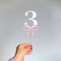Clear acrylic number 3 cake topper with pink bow design for birthday party cake decoration. - Double Layer Bow Number 3