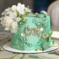 Detalle en primer plano de tarta de cumpleaños verde menta con topper acrílico y decoración. - Decoración de Tarta Feliz Cumpleaños Dorado 04