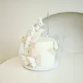 Gros plan de décorations de gâteau papillon blanc avec strass et bougie argentée. - Blanc