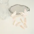 Vue détaillée de toppers gâteau papillon rose avec strass, parfaits pour table de fête. - Série Orange