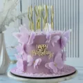 Close-up detail of acrylic happy birthday cake topper with purple butterflies and gold candles. - English Text Side Decoration / 1.3mm Thick/Width Approx 9cm / Gold