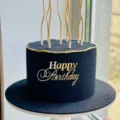 Detailopname van luxe zwart-gouden verjaardagstaart met acrylcake topper en stijlvolle kaarsen. - Minimalistische Letters Zijdecoratie / 1,3 mm dik/breedte ca. 9 cm / Goud