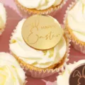 Gros plan d'un cake topper de Pâques en acrylique doré avec oreilles de lapin et texte. - Style de Texte HAPPY Easter / Largeur env. 5CM / Or