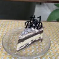 Detailed close-up of a black #1 dad cake topper placed on a delicious layered slice cake. - #1 Dad / Width Approx 5.5CM / Black
