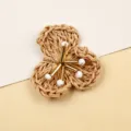 Detailed view of handmade woven straw flower accessory with metal stem and white bead center. - Yellow