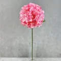 Close-up detail of a pink artificial hydrangea flower in a clear glass vase for home decor. - Pink
