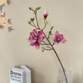 Nahaufnahme Detail künstlicher Magnolienzweig Blumenarrangement elegante Heimdeko. - Herbstviolett