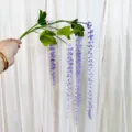 Rama de flores artificiales colgantes con tallos de perlas moradas y hojas verdes para decoración. - Violeta Claro
