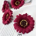 Artificial chrysanthemum flower close-up, deep red gerbera petals with yellow center detail. - Red