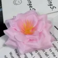 Vista detallada en primer plano de una flor de tela artificial rosa con estambres amarillos. - Rosa