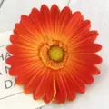 Primo piano di un fiore di gerbera artificiale arancione per decorazione tavola e ghirlande. - Tramonto