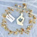 Figura de pensador de cerámica blanca con guirnalda floral dorada para decoración. - Enredadera de hoja de loto dorada