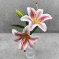 Gros plan de détail d'un arrangement floral de lys 3D artificiel avec deux fleurs, un bourgeon. - Taille 16