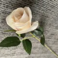 Gros plan de rose artificielle en velours, bourgeon champagne unique pour deco et accessoires. - Champagne