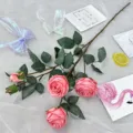 Artificial rose flower detail, pink floral branch with green leaves, home decor scene. - Pink