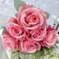 Dettaglio in primo piano di bouquet di rose in seta artificiale rosa con foglie per decorazione. - rosa pesca