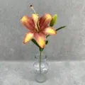 Close-up detail of a single stem artificial lily flower in a clear glass vase, home decor. - Burnt Orange