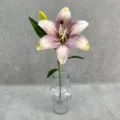 Close-up detail of artificial lily flower with realistic petals and clear glass vase stem decor. - Autumn Purple