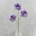Detail shot of artificial purple rose stem featuring three silk flower heads in a vase. - Deep purple