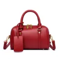 Chic solid red leather small Boston pillow bag with golden hardware and crossbody strap. - Red