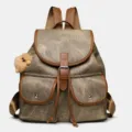 Vintage style canvas backpack with brown leather trim, dual front pockets and fluffy charm. - Brown