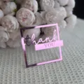 Gros plan du détail de cake topper en acrylique rose avec élégant cadre carré. - Rose Miroir Rouge