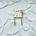 Detail shot of a shiny gold acrylic 40th birthday cake topper with elegant typography. - 40th Style / Width 11cm
