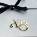 Gold acrylic letter cake topper and ribbon pendant, close-up view of elegant monogram. - XB1 Cupcake Toppers