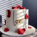 Elegant gold acrylic love cake topper decorated with red rose petals for Valentine's Day. - "Love" Cake Side Decoration