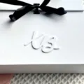 White gift box with black ribbon and custom script letter decor for elegant packaging. - White XB2 Cupcake Toppers