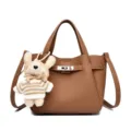 Brown leather bucket handbag with metal lock and cute plush rabbit pendant charm accessory. - Yellow Brown