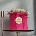 Close up detail of pink round flower gift box featuring white roses and wooden tag - Round Marking 3 / Gold