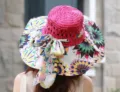 Schicker Damen Sonnenhut mit breiter Krempe, pinker Krone und bunter Schleife für Strand. - Fuchsia