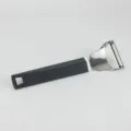 Stainless steel blade fruit peeler with ergonomic non-slip black textured handle detail. - Gourd-Shaped Graters