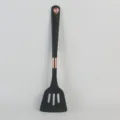 Spatule ajourée en silicone noir avec accents en or rose, idéale pour la cuisine antiadhésive quotidienne. - Spatule Perforée