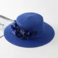 Detailaufnahme des eleganten blauen Strohhutes mit Stoffblumen und funkelnden Strasssteinen. - M (56-58cm) / Saphirblau