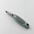 Stainless steel dual-head kitchen vegetable peeler featuring green and grey ergonomic handle. - Peeler