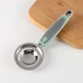 Stainless steel egg white separator with green plastic handle, durable kitchen tool for baking. - Egg White Separator